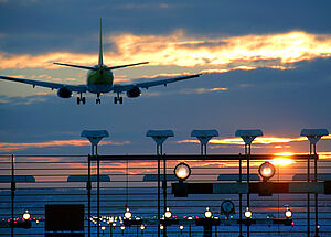 Airplane starts on runway into sunset