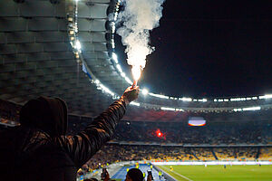 Fan mit Fackel in einem Stadion 