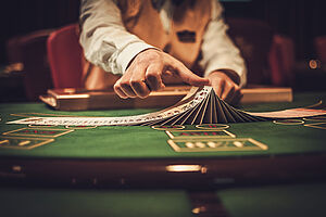 croupier dealing poker cards at a gambling table in a casino
