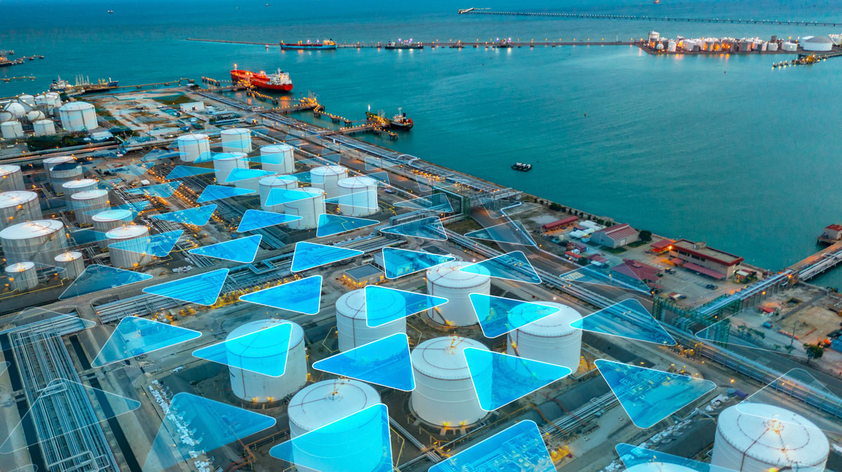 Aerial view of a harbor with large storage tanks and vessels in the water, overlaid with blue triangular graphics indicating data or analysis points.