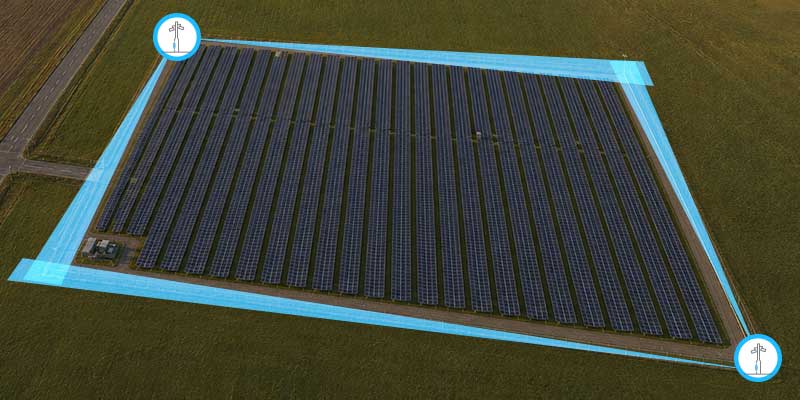 Aerial view of a large solar panel field, with rows of solar panels arranged neatly, outlined by a blue digital boundary.