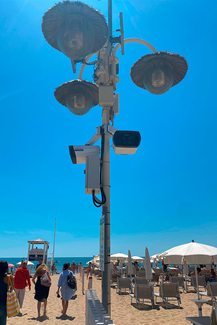 Zwei Dallmeier Panomera® Überwachungskameras hängen an einem Laternenmast am Strand.